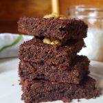 Stack of Brownies on a plate with milk in background